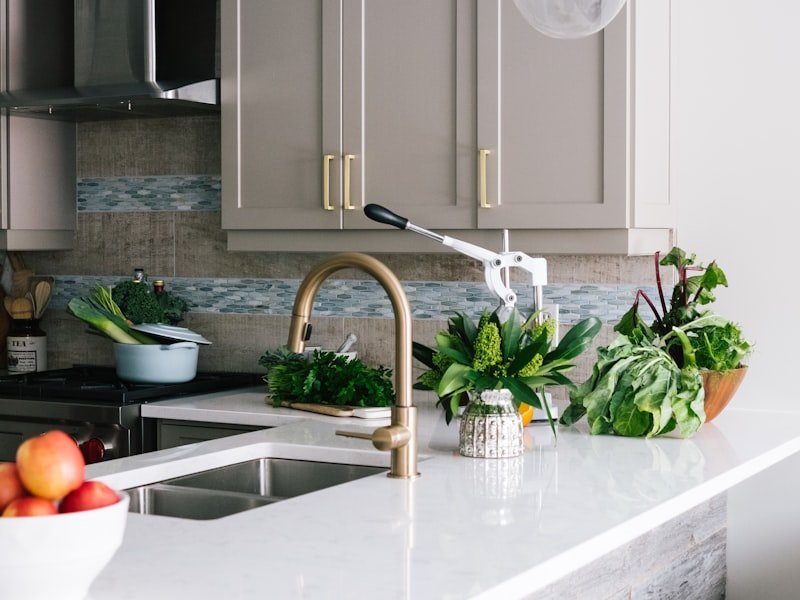 Quartz waterfall island with brass faucet in mid-renovation Vancouver kitchen